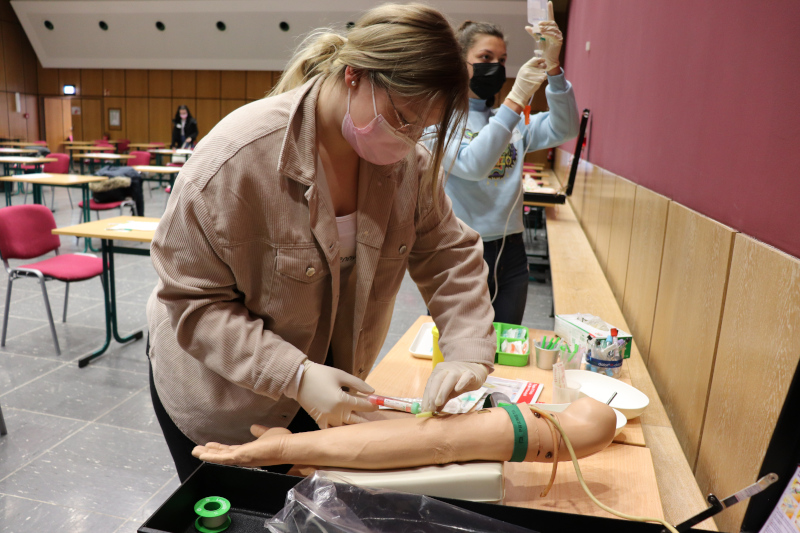 Eine Schülerin übt an einem künstlichen Arm